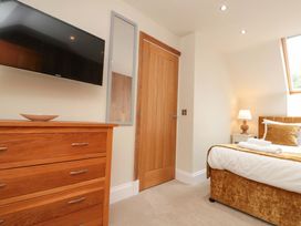 A bedroom with a TV and a dresser at Clematis Cottage in Whitby