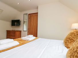 A bedroom with a bed and television at Clematis Cottage in Whitby