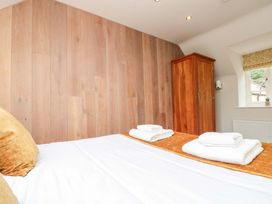 A bedroom with a bed and wardrobe at Clematis Cottage in Whitby