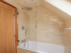 A bathroom with a bathtub and a shower at Clematis Cottage in Whitby
