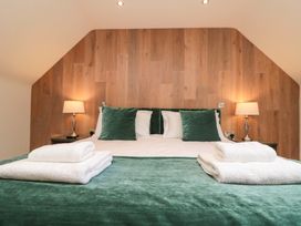 A bedroom with a large bed and bedside lamps at Clematis Cottage in Whitby