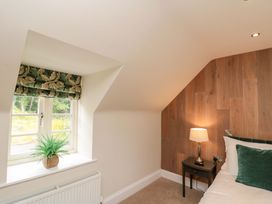 A bedroom with a lamp and plant at Clematis Cottage in Whitby