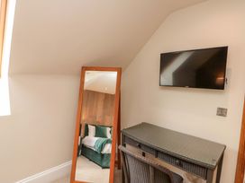 A bedroom with a mirror, desk, and television at Clematis Cottage in Whitby