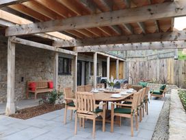 An outdoor dining area with a wooden table and chairs at Lower Moorwood in Moorwood near Bovey Tracey