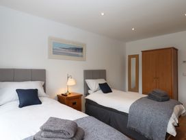 A bedroom with two beds and a wardrobe at Lower Moorwood in Moorwood near Bovey Tracey