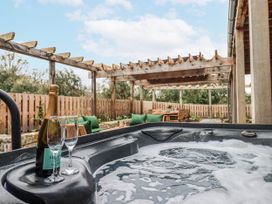 An outdoor area with a hot tub and seating at Lower Moorwood Moorwood near Bovey Tracey