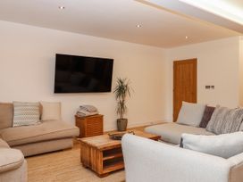 A living room with a television and sofa at Lower Moorwood in Moorwood near Bovey Tracey