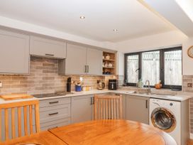 A kitchen with cabinets and a washing machine at Lower Moorwood in Moorwood near Bovey Tracey