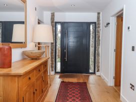 A hallway with a console table and front door at Lower Moorwood Moorwood near Bovey Tracey