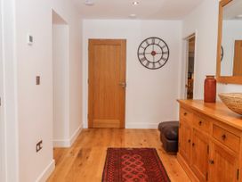 A hallway with a clock and wooden furniture at Lower Moorwood in Moorwood near Bovey Tracey