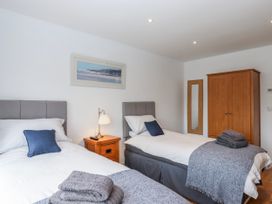 A bedroom with twin beds and a wooden wardrobe at Lower Moorwood in Moorwood near Bovey Tracey