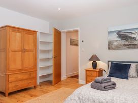 A bedroom with a bed and wardrobe at Lower Moorwood in Moorwood near Bovey Tracey