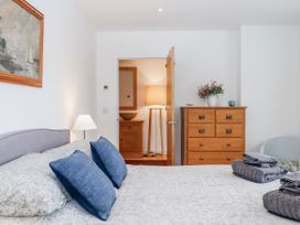 A bedroom with a bed and dresser at Lower Moorwood in Moorwood near Bovey Tracey