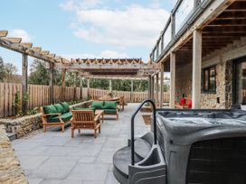 An outdoor patio area with a hot tub and seating at Lower Moorwood in Moorwood near Bovey Tracey