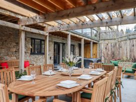 An outdoor dining area with a wooden table and chairs at Lower Moorwood in Moorwood near Bovey Tracey
