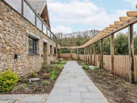 A garden with a stone wall and a pathway at Lower Moorwood in Moorwood near Bovey Tracey