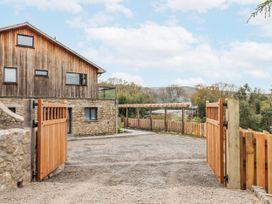 An outdoor view of a house with a wooden gate and gravel driveway at Lower Moorwood in Moorwood near Bovey Tracey