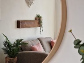 A living room with a sofa and a plant at Plas Darien Apartment 7 in Trearddur Bay