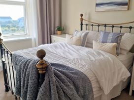 A bedroom with a bed and window at Plas Darien Apartment 7 Trearddur Bay