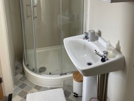 A bathroom with a shower and sink at Plas Darien Apartment 7 in Trearddur Bay
