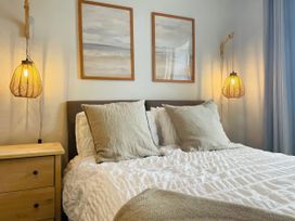 A bedroom with a bed and lamps at Plas Darien Apartment 7 Trearddur Bay