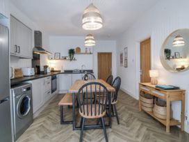 A kitchen with a dining table and chairs at No.7 Plas Darien, Trearddur Bay