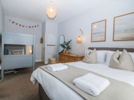 A bedroom with a double bed and bunk bed at No.7 Plas Darien Trearddur Bay