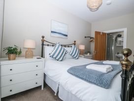 A bedroom with a bed and bedside lamp at No.7 Plas Darien, Trearddur Bay