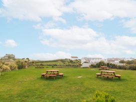 An outdoor area with picnic tables and grass at No.7 Plas Darien Trearddur Bay