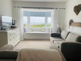 A living room with a window seat and television at No.7 Plas Darien in Trearddur Bay