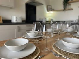 A dining table set with plates, bowls, and glasses at No.7 Plas Darien Trearddur Bay