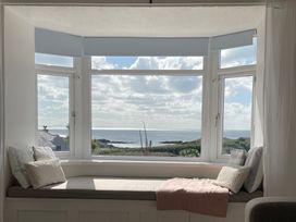 A window seat with cushions and a throw blanket at No.7 Plas Darien Trearddur Bay