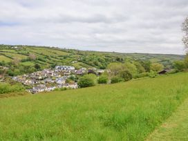 A green grassy field overlooking a village with houses and rolling hills in the background at 26 Manleigh Park in Combe Martin