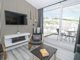A living room with a television and fireplace at Harbwr Hideaway in Porthmadog