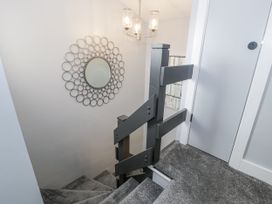A staircase with a mirror and light fixture at Harbwr Hideaway in Porthmadog