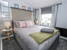 A bedroom with bed and window at Harbwr Hideaway in Porthmadog