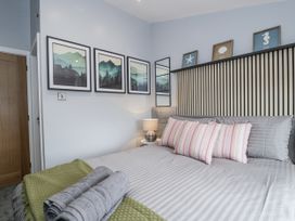 A bedroom with a bed and pictures on the wall at Harbwr Hideaway in Porthmadog