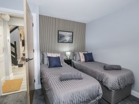 A bedroom with two single beds at Harbwr Hideaway in Porthmadog