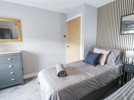 A bedroom with two beds and a mirror at Harbwr Hideaway in Porthmadog