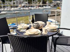 An outdoor dining table set with plates and drinks at Harbwr Hideaway in Porthmadog