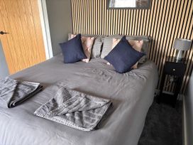 A bedroom with a bed and lamps at Harbwr Hideaway in Porthmadog