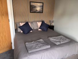 A bedroom with a double bed and cushions at Harbwr Hideaway in Porthmadog
