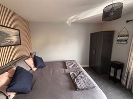 A bedroom with a bed and wardrobe at Harbwr Hideaway in Porthmadog