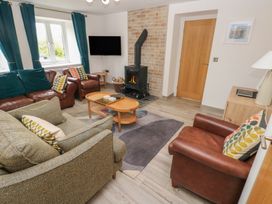 A living room with a sofa, armchairs, and a fireplace at Folly Cottage Llanteg near Saundersfoot