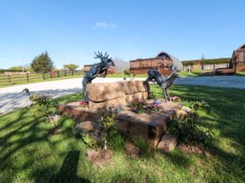 A garden with deer sculptures and flowers at Hazel Lodge in Whitby