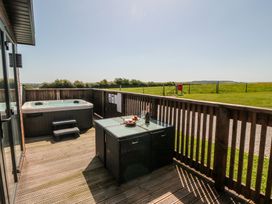 An outdoor seating area with a hot tub and table at Willow Lodge in Whitby