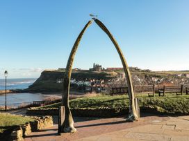 A whale bone arch with benches in front of the sea at Magnolia Lodge in Whitby