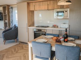 A kitchen with dining table and appliances at Magnolia Lodge in Whitby