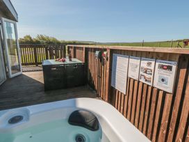 An outdoor area with a hot tub and seating at Magnolia Lodge in Whitby