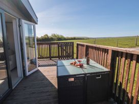 A deck with a table and chairs at Magnolia Lodge in Whitby